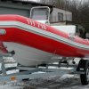 Barevná kombinace červeného materiálu Valmex a světle šedých doplňků na válcích standardního člunu RIB Adventure V-450 Luxury s lodním motorem Evinrude E-TEC E40DSL. Modelový rok 2013.