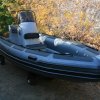 Nafukovací motorový člun RIB Adventure V-585 ve verzi PROFI s konzolou SL-2H a opěrkou kapitána SLS-4, vše v edici Carbon Black (polstrování, nerez.rámy, plexi). Od standardní verze Heavy Duty se mj.odlišuje silnějším materiálem plováků